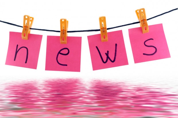 pink post it notes clothespinned to a line spelling out news