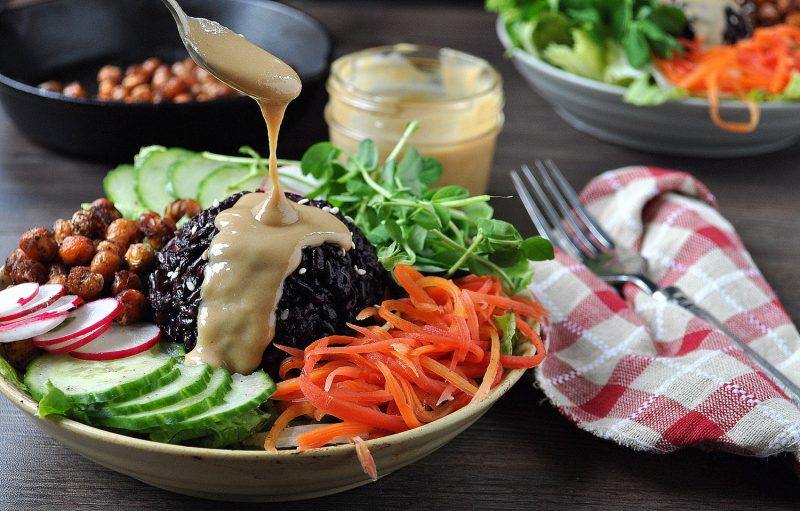 Buddha Bowl with dressing dripping on to it
