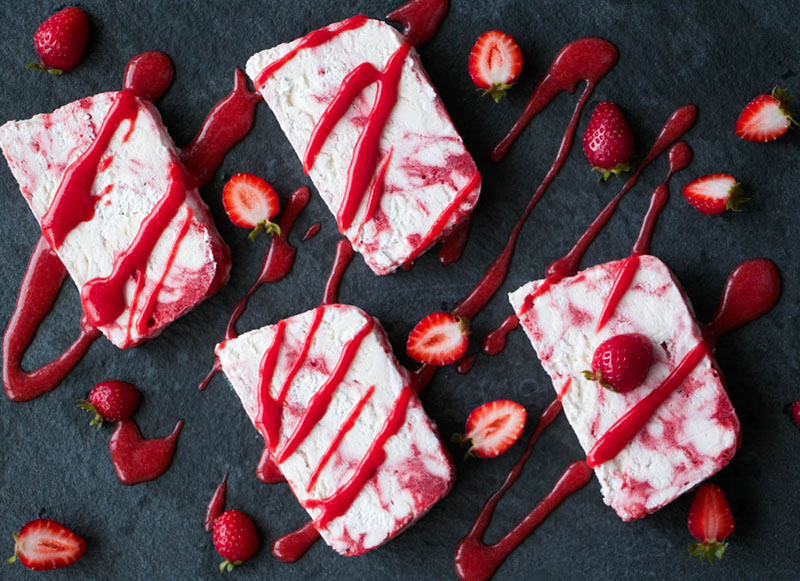 Sliced Strawberry Rosewater Semifreddo drizzled with strawberry puree.