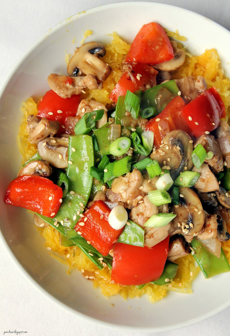 A plate of garlic chicken and veggies on a bed of spaghetti squash