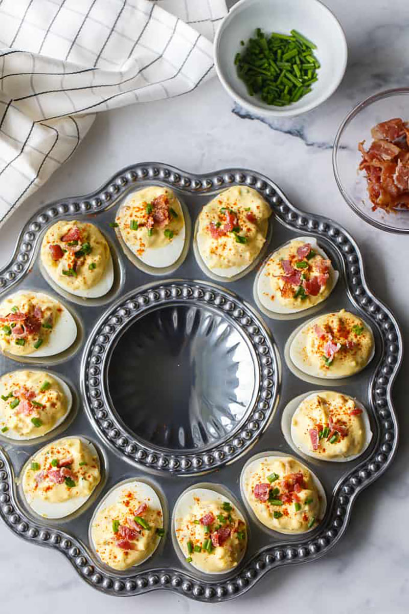 A silver tray full of bacon ranch deviled eggs