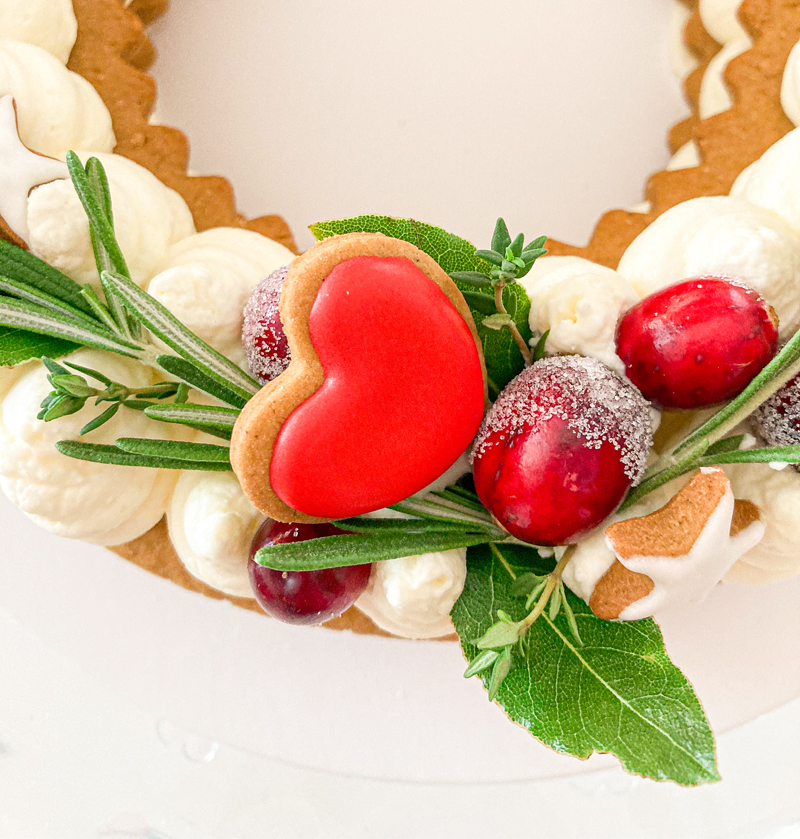 Close photo of cake with cookie heart and rosemary.