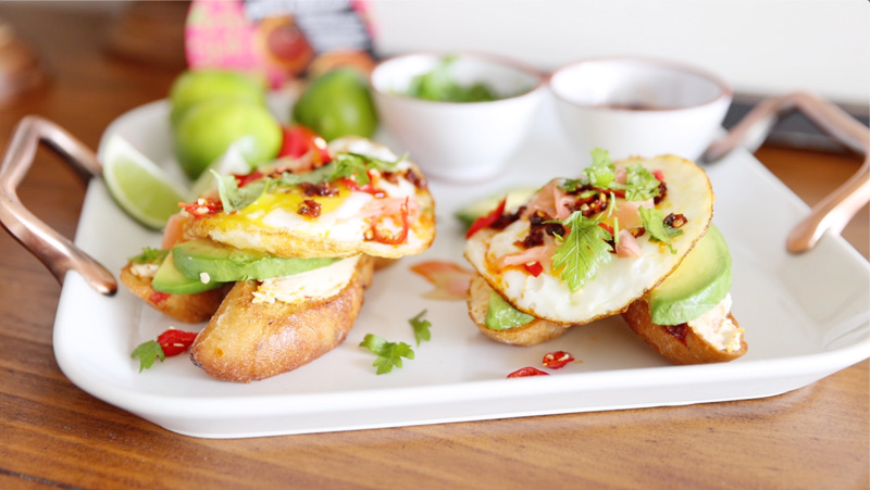 Aocado toast with egg served on white plate.