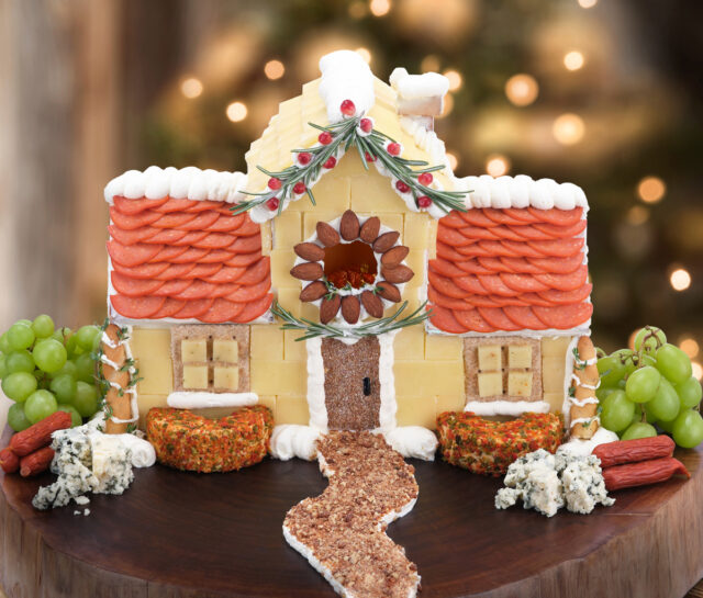 Charcuterie Christmas house with cheese, pepperoni, almonds, cream cheese.