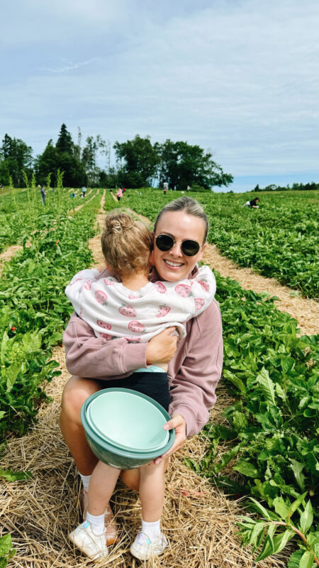 Mother and daughter on a field hugging.